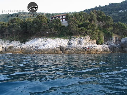 The rocky shoreline below the house seen from the water