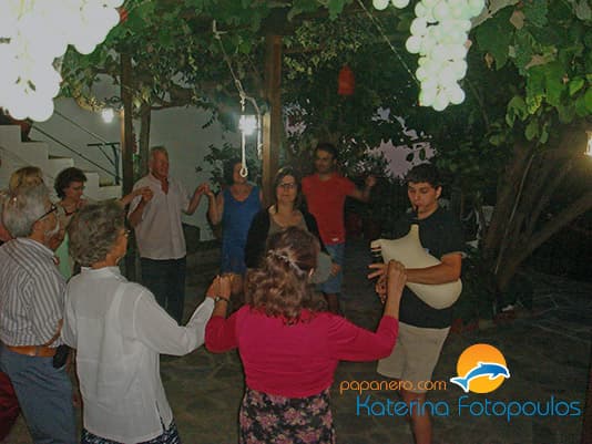 Guests dancing under the vine on the terrace on a summer evening